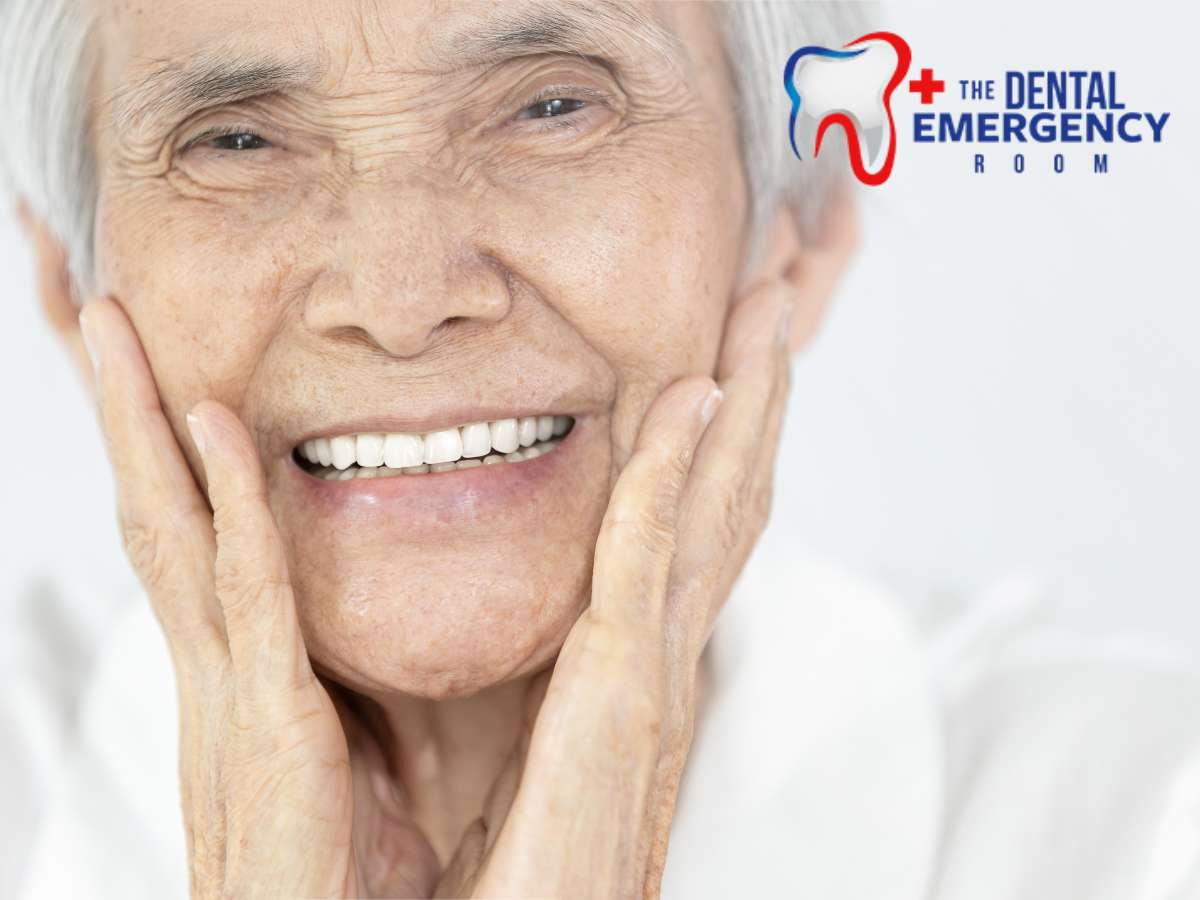 Joyful elderly Asian man with new dentures smiling and touching his face, with The Dental Emergency Room logo in the corner